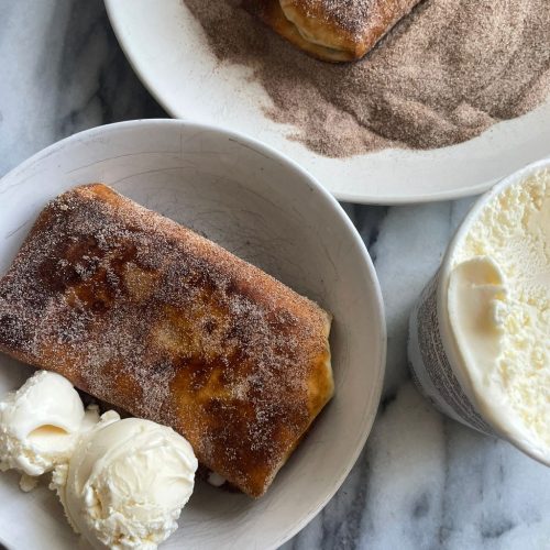 Burrito covered in cinnamon sugar in a bowl with ice cream